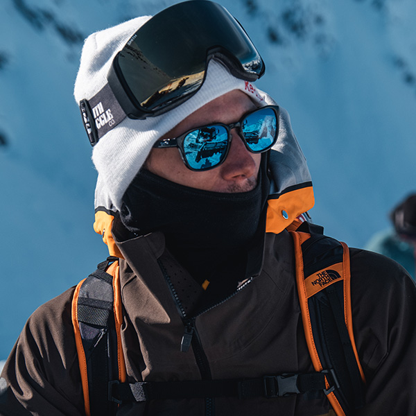 man wearing blue polarized smith sunglasses with his black north face ski clothing