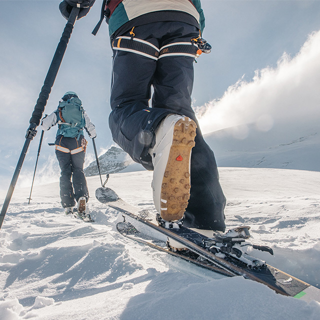 two people going uphill on a ski tour using Salomon touring skis