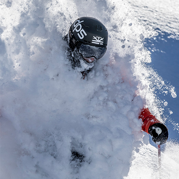 person skiing in deep powder snow with DPS skis and a black DPS helmet