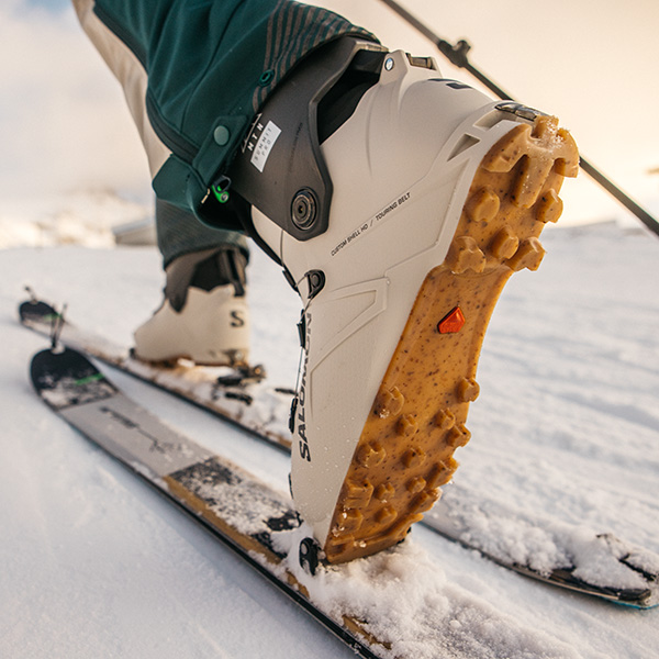 upclose view of salomon alpin touring ski boots and skis while the skier walks uphill