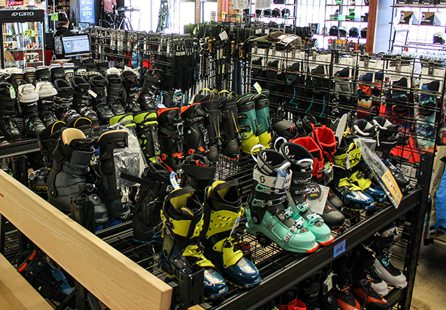 consigned ski boots on metal shelves in a retail store